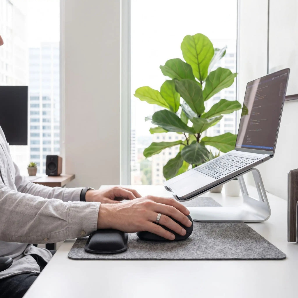 Bureau de travail avec accessoires ergonomiques et mains d'homme qui utilise souris