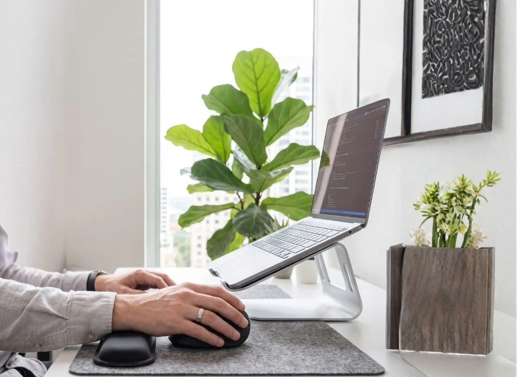 Bureau de travail avec accessoires ergonomiques et mains d'homme qui utilise souris