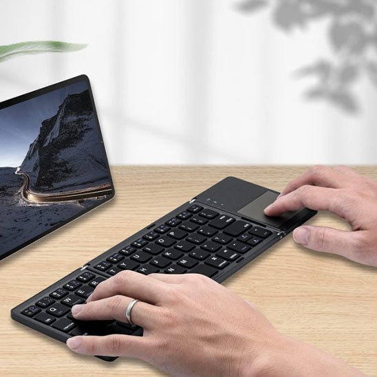 Clavier bluetooth avec pavé tactile utilisé devant une tablette numérique