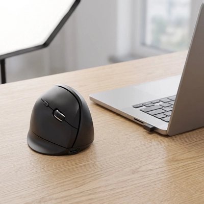 Souris ergonomique sans fil noire près d'un ordinateur portable