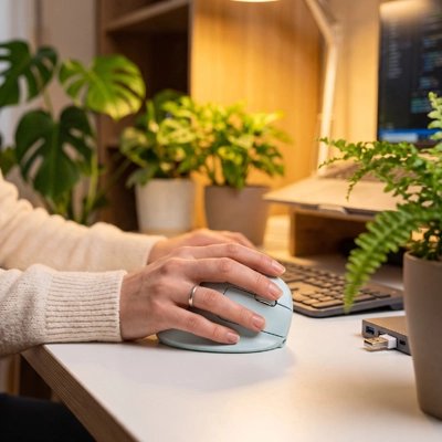 Souris ergonomique sans fil bleue avec femme à son poste de travail ergonomique
